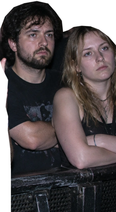 The other concertgoers stare at the stage with their arms folded.